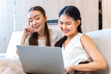 Farklı kültürlerden kadın ev arkadaşları evde birlikte film izliyorlar. İlişki ve eğitim için dizüstü bilgisayardan.