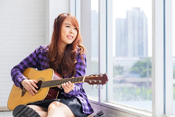 Glad Asiatisk Kvinna Musiker Håller Gitarr Medan Sitter Vid Fönstret — Stockfoto