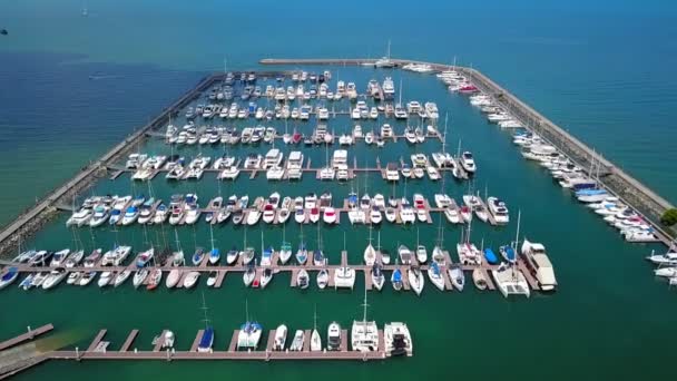 Port maritime pour yacht, bateau à moteur, service de stationnement de voilier et d'amarrage pour le luxe et riche millionnaire en vue aérienne avec de nombreux navires ancrant le long de la baie du quai — Video