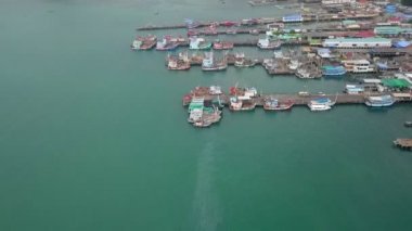 Balıkçı rıhtımının havadan görünüşü. İç kısımlara deniz ürünleri ve erzak taşımak için demirleyen birçok balıkçı gemisi var.