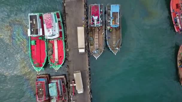 Vista aérea del muelle de pescadores que tiene muchos buques pesqueros anclando para el transporte de mariscos y suministros tierra adentro — Vídeo de stock