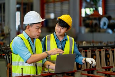 Asyalı mühendis ekibi çelik imalat fabrikasını teftiş ederken aynı zamanda üst düzey yöneticilerin kapasite ve verimliliğin artırılması konusundaki tavsiyelerini dinliyor.