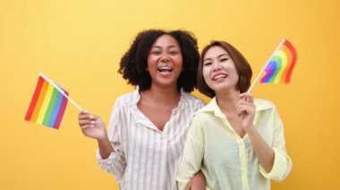 Eşcinsel ve ayrımcılık kavramının eşitliği ve farklılıklarını desteklemek için LGBTQ gökkuşağı bayrağı sallayan çeşitli kadın aşıkları