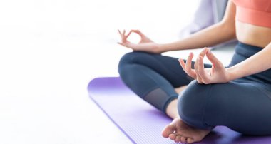 Kapalı alanda yoga yapan Asyalı kadın meditasyon poziyonunda nefes alıp vermeyi kontrol etmek için kolay ve basit bir pozisyonda duruyor.
