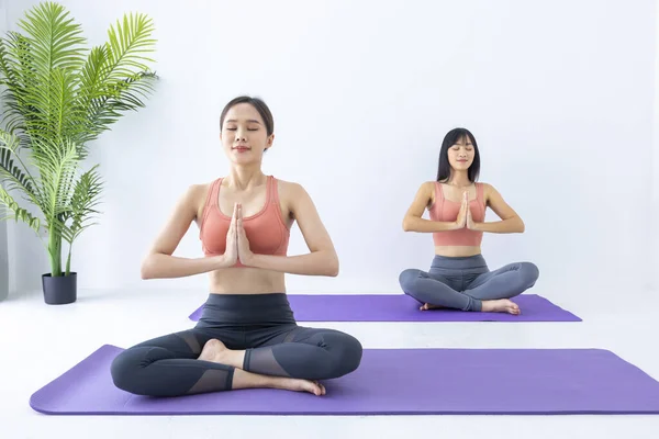 Asian woman practicing yoga indoor with easy and simple position to control breathing in and out in meditation posture