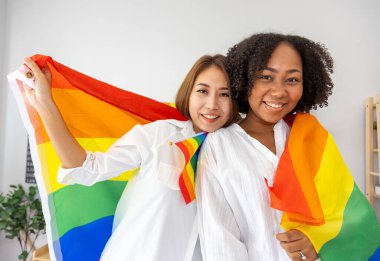 Eşcinsel ve ayrımcılık kavramının eşitliği ve farklılıklarını desteklemek için aynı cinsiyet evliliği farklı ırklarda LGBTQ gökkuşağı bayrağı taşıyor.