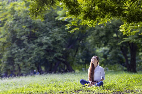 Woman relaxingly practicing meditation in the forest to attain happiness from inner peace wisdom for healthy mind and soul concept