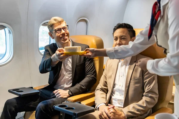 Flight attendant is serving food to customer for in flight meal, airline travel and transportation concept