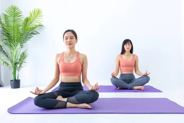 Asian woman practicing yoga indoor with easy and simple position to control breathing in and out in the meditation pose