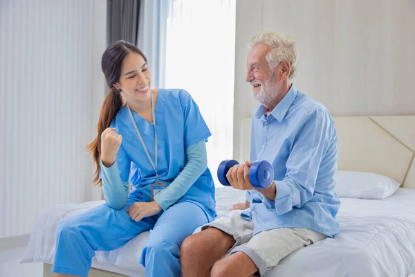Hospice Nurse Helping Caucasian Man Bed Exercising Muscle Strength Pension —  Fotos de Stock