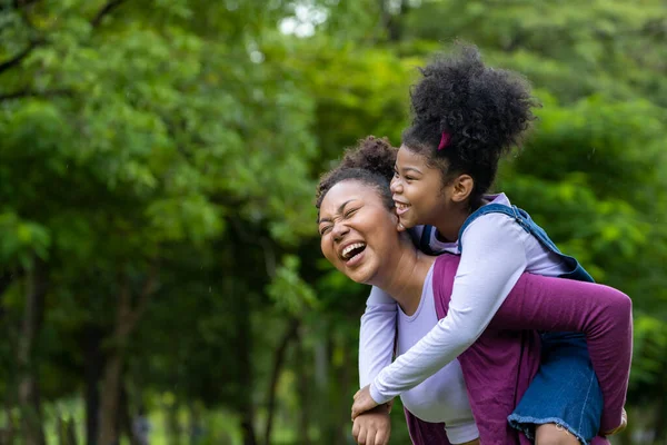 African American Mother Playing Piggyback Riding Her Young Daughter While — ストック写真