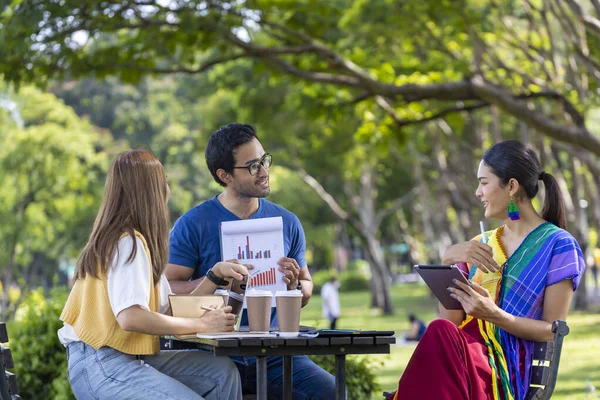 Group of Asian business startup people having a meeting project outside in the public park during the summer for college education and brainstorming concept