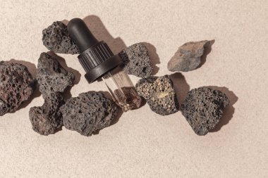 Aromaterapi ve bej zemin üzerinde volkanik taşlar bulunan mineral yayıcı için gerekli yağ. Aromaterapi, spa, güzellik tedavisi ve sağlık konsepti.