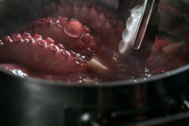 Bütün ahtapot su ve sebzelerle dolu tencerede kaynıyor. Kırmızı ahtapot dokunaçları kaynatılıyor