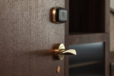 Güvenli erişim için otelin ahşap kapısında modern elektronik kart kilidi var. Otel güvenlik sistemi kavramı