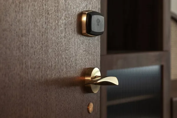 Güvenli erişim için otelin ahşap kapısında modern elektronik kart kilidi var. Otel güvenlik sistemi kavramı