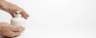 Adam elleri dezenfektanla dezenfekte ediyor. Kişisel hijyen rutinleri COVID-19 koronavirüsünün yayılmasını önlemeye yardımcı oluyor