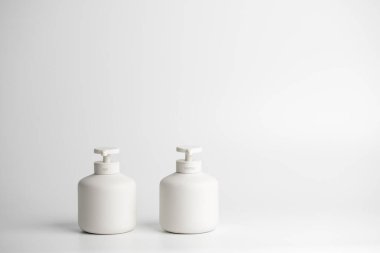 Temizleyici ve sabun için pompalı beyaz minimalist seramik kutular. COVID-19 Coronavirus konsepti. Virüs önleme, kişisel hijyen rutinleri 