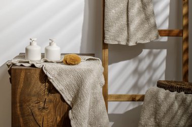 Organik waffle keten havluları, sabun ve losyon kutuları modern banyo içlerindeki sert meşe kütüğünde deniz süngeri. Günlük vücut bakımı, spa ve sıhhat sıfır atık tuvalet kavramı