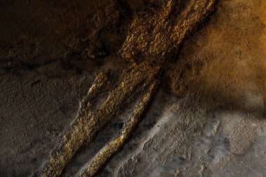 Parlak altın tozlu gri beton duvar. Çatlaklı ve kusurlu kil duvar dokusu. Modern iç konsept