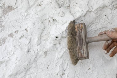 Beyaz desenli kil duvar oluşturma süreci çatlaklar ve kusurlarla, fırça kullanarak. Çağdaş iç mekanlarda duvar tasarımı fikirleri. 