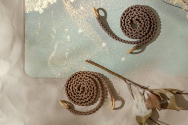 Yuvarlanmamış yoga minderi, kumlu sahilde esnemek ve kuru yapraklar için örülmüş halatlar. Rahatlama ve meditasyon refah ve bilinçli yaşam konsepti