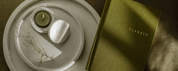 Zeytin yeşili planlayıcı ve beyaz minimalist beton şamdanlı çay ışığı mumu. Defter ve kırtasiye malzemeleri. Somut modern ev aksesuarları. 