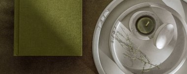 Zeytin yeşili planlayıcı ve beyaz minimalist beton şamdanlı çay ışığı mumu. Defter ve kırtasiye malzemeleri. Somut modern ev aksesuarları. 