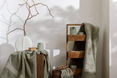 Okaliptüs rengi açık yeşil tonda modern estetik banyo aksesuarları. Organik pamuklu banyo havluları, minimalist İskandinav tarzı vazo, sensör sabunu ve somut meşe kütüğünde losyon makinesi. Günlük vücut bakımı, spa ve sağlık banyosu konsepti