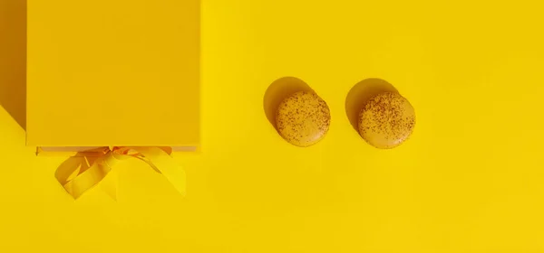 Κίτρινο Κουτί Δώρου Κορδέλα Φιόγκο Και Δύο Γαλλικά Αμυγδαλωτά Κίτρινο — Φωτογραφία Αρχείου