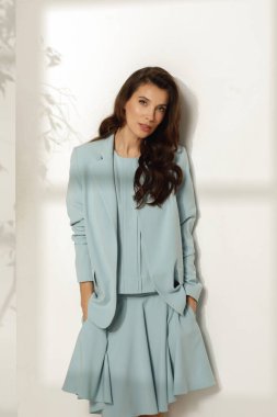 Moda bahar kıyafeti giyen kadın model, beyaz arka plana karşı mavi günlük takım elbise. Bahar, yaz moda konsepti