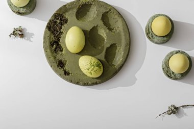 Sıfır atık Paskalya kavramı. Paskalya yumurtaları yosun yeşili çimento tepsisinde kibrit çayıyla boyanmış. Çevre dostu yaşam tarzı. Modern ve çağdaş içsel detay kavramı. 