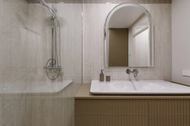Modern minimalist banyo iç tasarımı mermer taş fayanslar ve haki rengi mobilyalar.