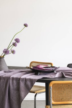 Seramik masa takımı, tabakta patlıcan, vazoda dekoratif sarımsak. Keten masa örtüsü üzerinde mevsimlik sebzeler ve çiçekler. Yaz tatili konsepti için açık masa ayarları.