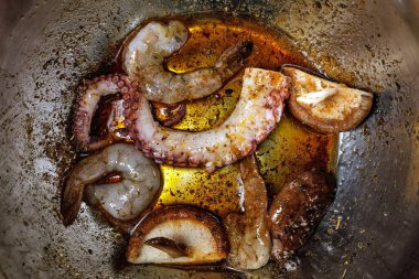 Çiğ deniz ürünleri metal karıştırma kabında marine ediliyor. Deniz ürünleri ızgara için hazır.