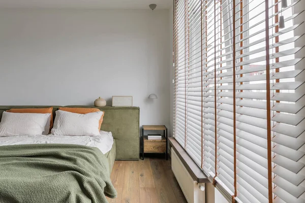 Modern Japandi bedroom interior design in moss green tones, natural textures with wooden shades, oak furniture. Japandi concept