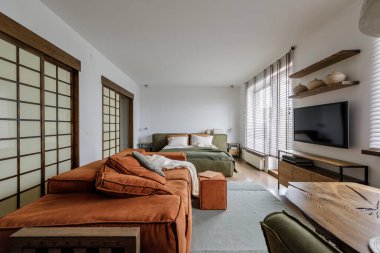 Modern Japandi iç dizayn dairesi toprak tonlarında, ahşap meşe mobilyaları ve sürgülü Japon ahşap kapıları olan doğal dokular. Japandi kavramı