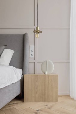 Modern minimalist bedroom interior design with grey furniture, oak floor in Scandinavian style.  Aesthetic simple interior design concept.