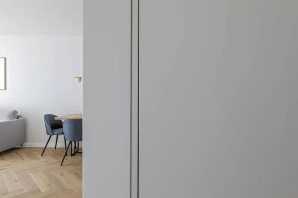 Modern minimalist kitchen and dining room interior design  with wooden furniture, oak floor. blue chairs.  Aesthetic simple interior design concept.