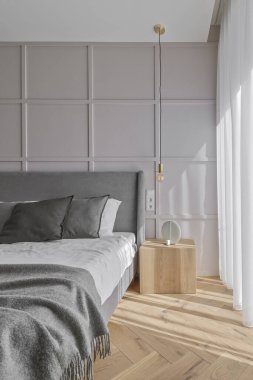 Modern minimalist bedroom interior design with grey furniture, oak floor in Scandinavian style.  Aesthetic simple interior design concept.