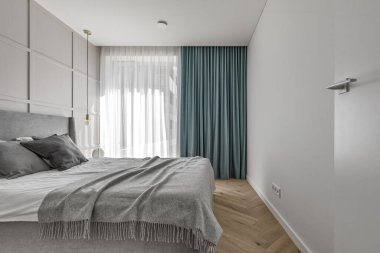 Modern minimalist bedroom interior design with grey furniture, oak floor in Scandinavian style.  Aesthetic simple interior design concept.