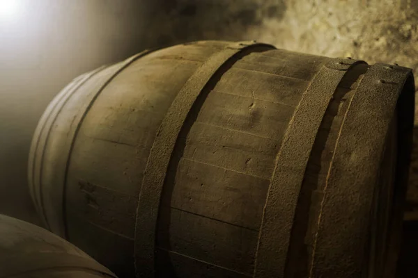 暗い暖かい地下室の雰囲気の中で非常に古代のワイン樽に対する浅い焦点光効果 ストックフォト