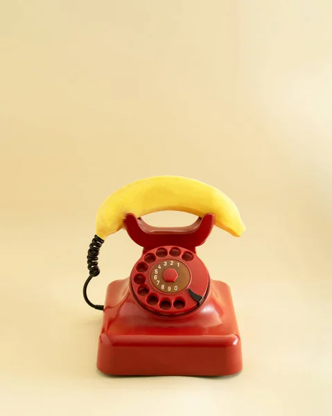 Teléfono Rojo Retro Con Plátano Fresco Amarillo Imitando Teléfono Handset Fotos de stock