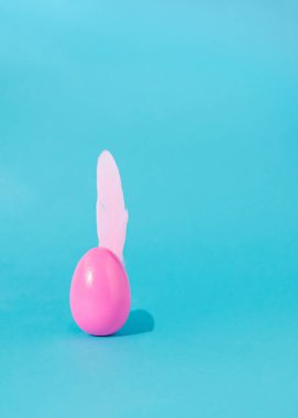 Yumuşak tüylü paskalya pembe yumurtası. Açık mavi arkaplan. Bahar tatili estetik modern tasarım