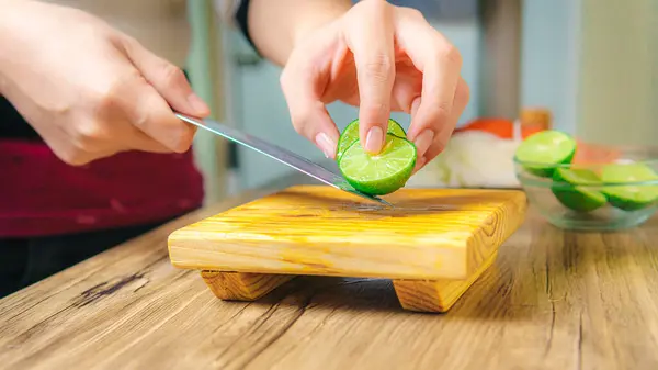Table Hand Knife Cutting Green Lemons Wooden Board — Zdjęcie stockowe