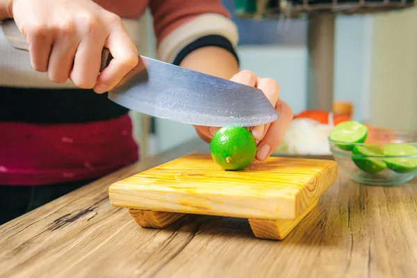 Table Hand Knife Cutting Green Lemons Wooden Board — Zdjęcie stockowe