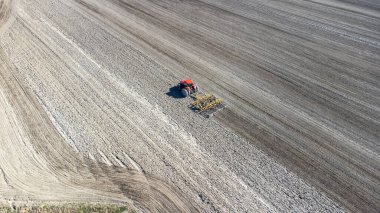 Traktör baharda tarlayı hazırlıyor. Drone görünümü.