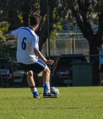 Amatör bir futbol maçında topa vurup koşan oyuncular.