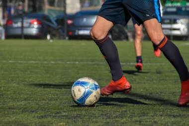 Amatör bir futbol maçında topa vurup koşan oyuncular.