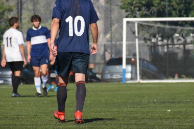 Amatör bir futbol maçında topa vurup koşan oyuncular.